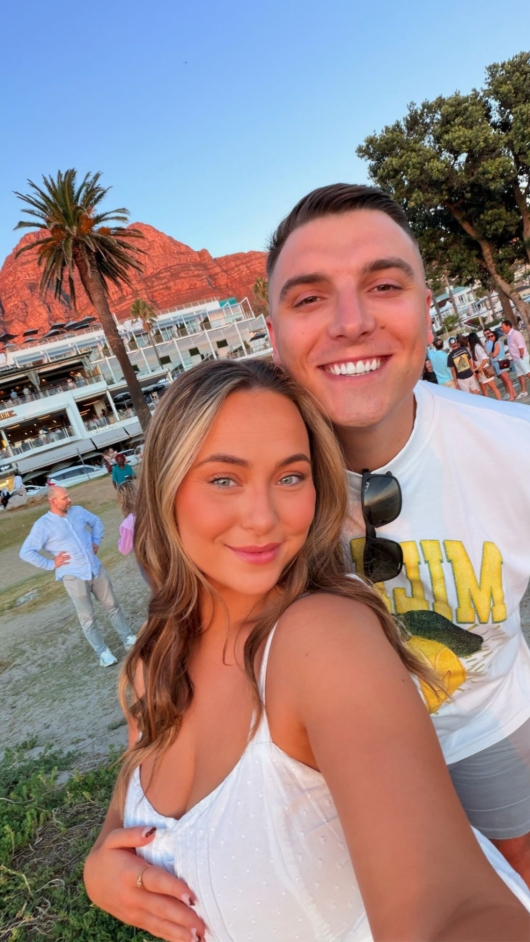 Victoria and Jamie on the beach with the mountains behind them