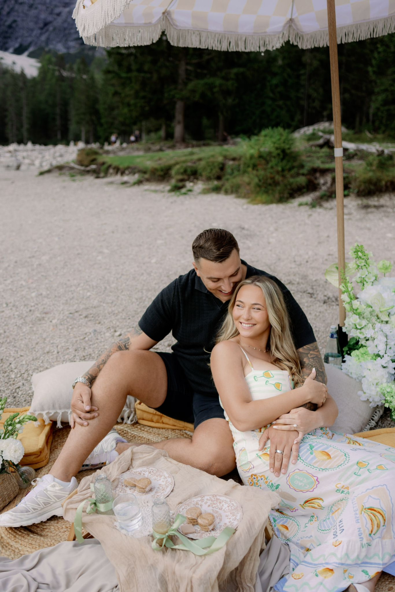 Victoria and Jamie on a picnic rug beside the lake in the Dolomites