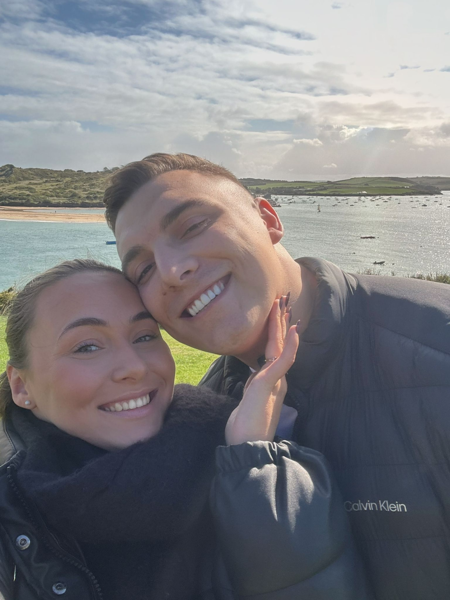 Victoria and Jamie cheek to cheek on a windy coastal walk